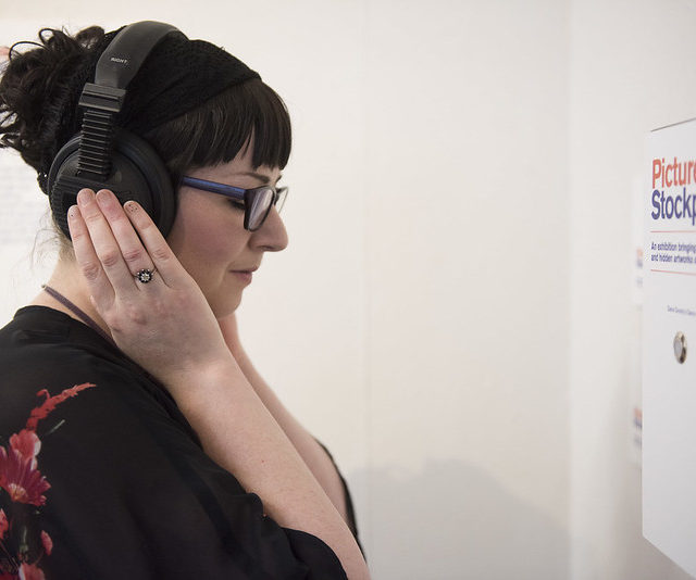 image of women listening to audio with headphones on her head