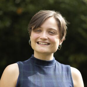 Image of Sarah a woman with short hair smiling with a blue top on