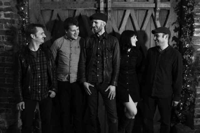 Image of the Nutmegs one woman and three men stood in a line in black and white