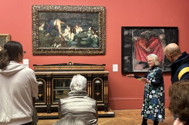 A photo of visitors at the gallery looking at paintings.