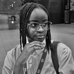 Image of Tolu - a young person with long black braids and glasses