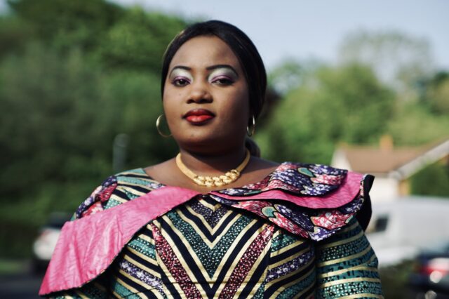 A black women dressed in colourful clothes