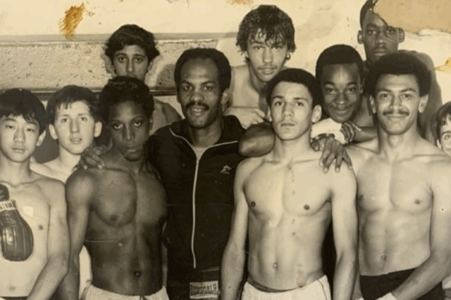 Image of a group of black boxers standing in a group with boxing gloves on
