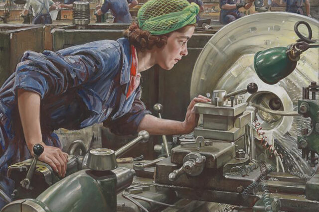 A woman leaning over a machine - she is dressed in WW2 overalls and has a green headscarf wrapped around her hair